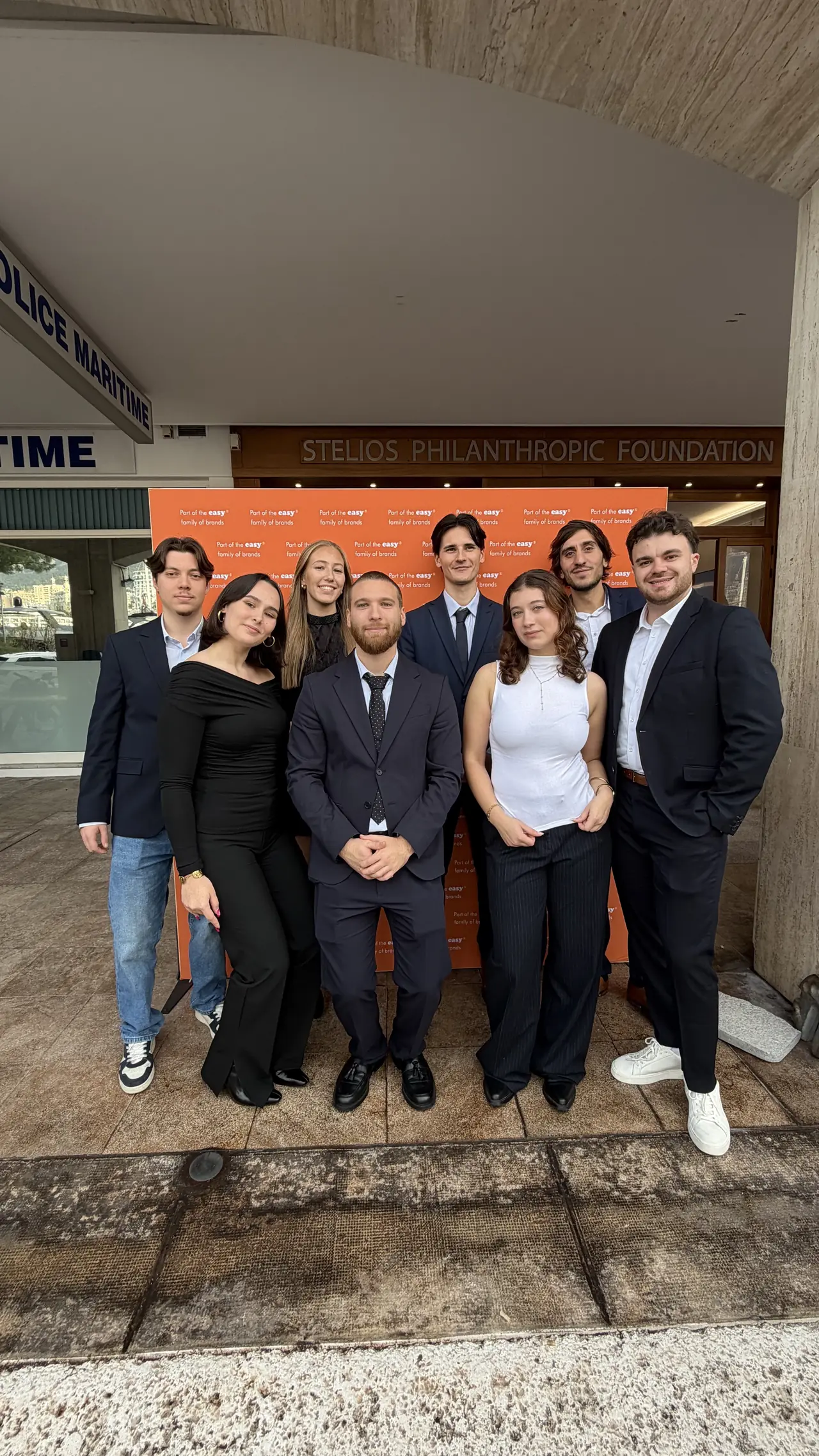 L'équipe easyVirtual.tours réunie devant le mur « Part of the easy family of brands », à la Stelios Philanthropic Foundation