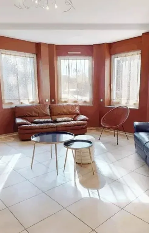 Living room furnished with leather sofas, before decluttering