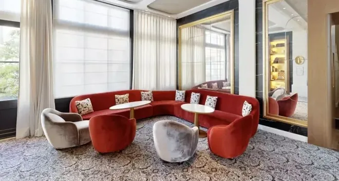 Hotel lounge with a red banquette and armchairs, seen in the tour