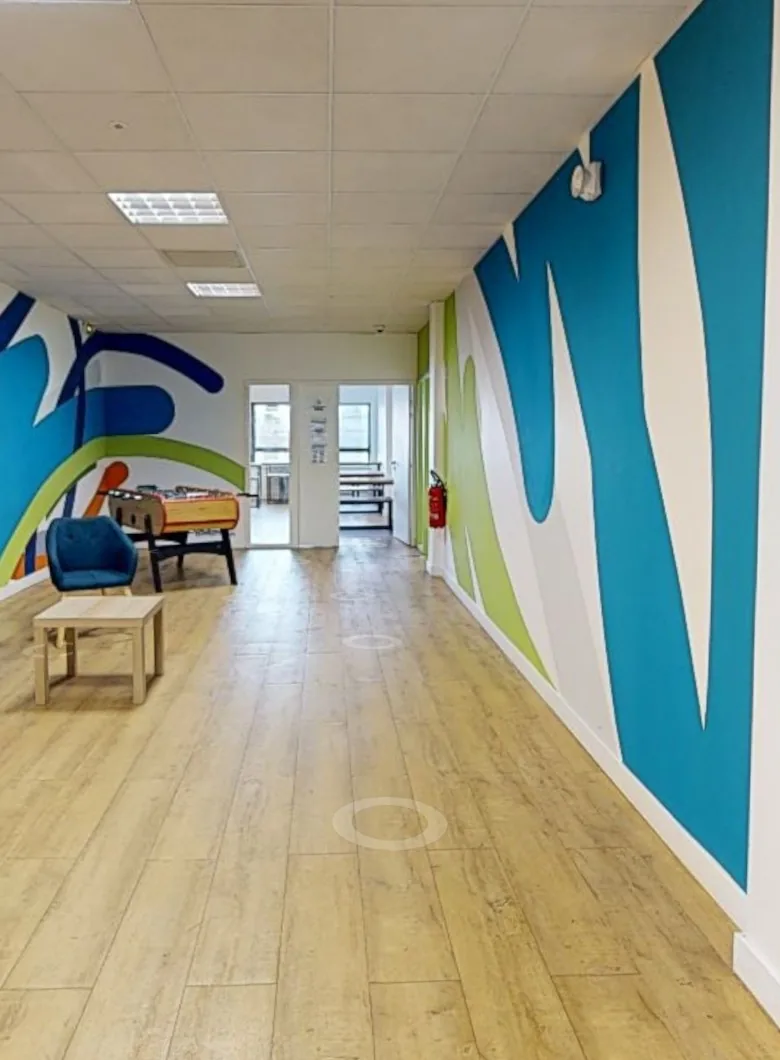Salle de pause aux murs colorés avec baby-foot, vue dans la visite