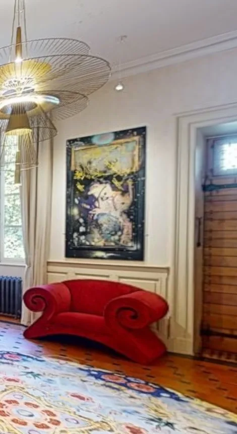 Grand salon d'un château avec fauteuil rouge et tableau, vu dans la visite