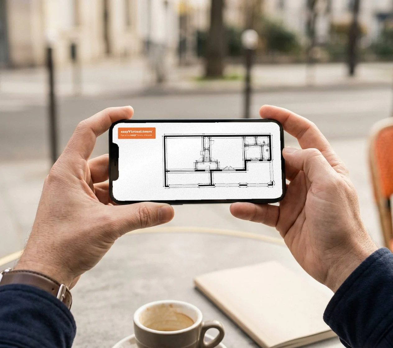 Dimensioned 2D plan in easyVirtual.tours colours, logo at the top, viewed on a smartphone on a café terrace