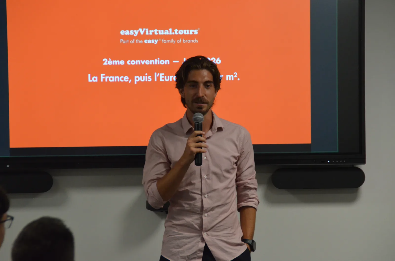Franchisee at the microphone in front of the screen at the network's second convention