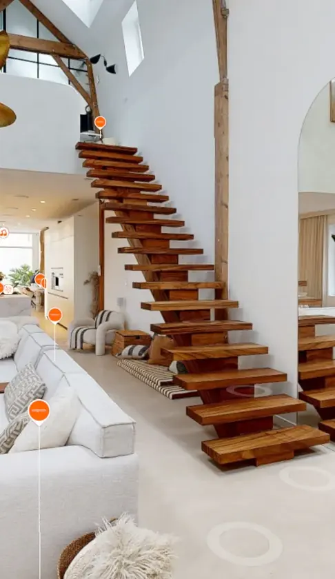 Double-height loft with a floating wooden staircase, seen in the sample tour