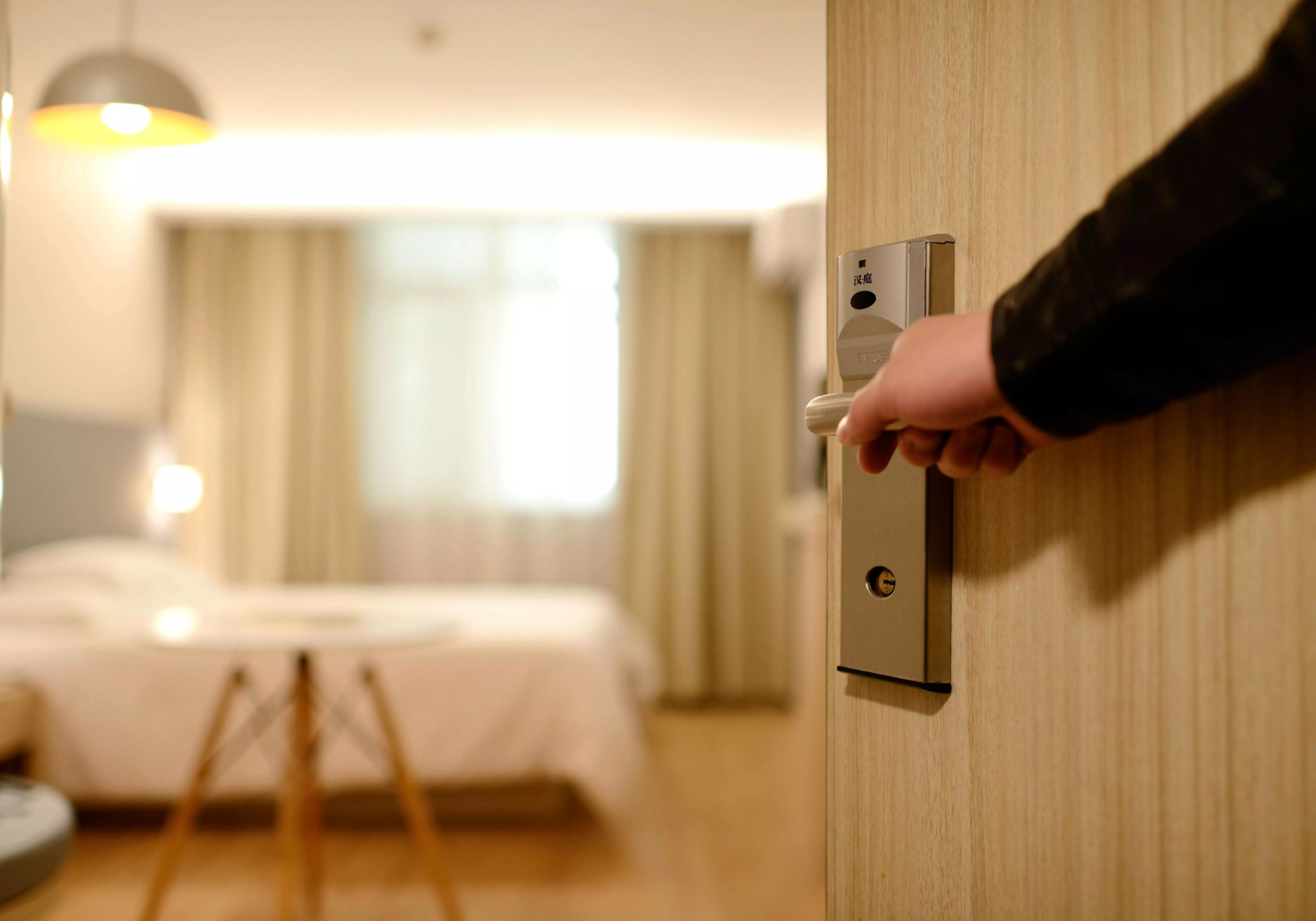 Main d'homme qui ouvre la porte d'une chambre d'hôtel