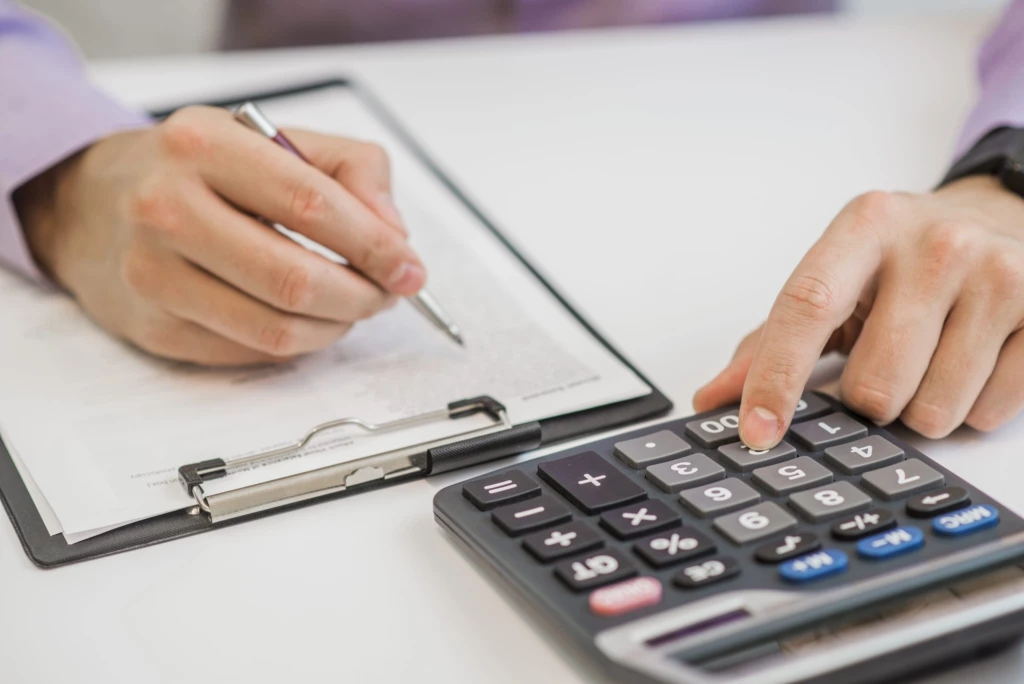 gros-plan-homme-affaires-calculer-factures-aide-calculatrice-scaled